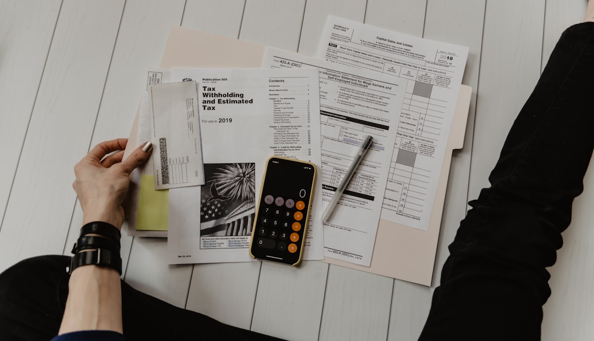 Calculadora, notas e documentos financeiros sobre uma mesa
